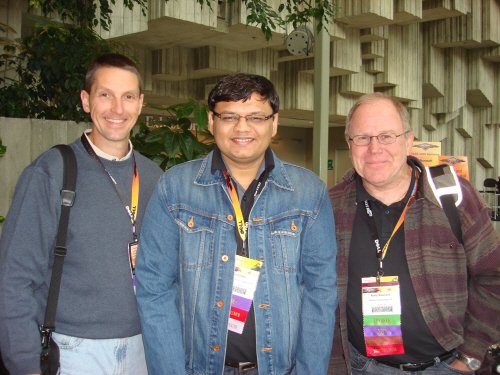 Three individuals with lanyards at an event.